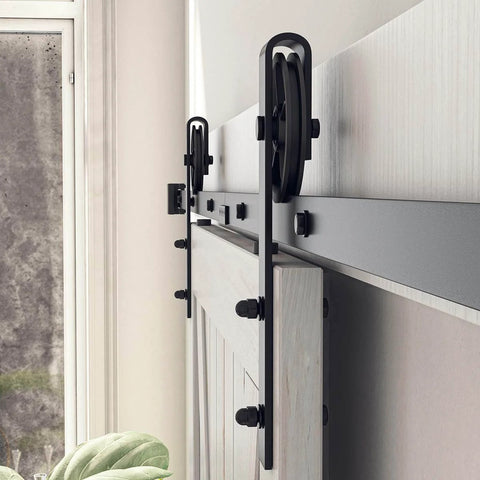 Side view of installed Beefy 8 Foot Sliding Barn Door Hardware Kit Black Track System with steel big wheel hangers on a wooden door.