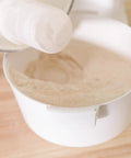 High Speed Grain Mill With 1200 Watt Motor Delivers Fresh Flour Fast No Fuss Milling Quiet Operation And 5 Cups Per Minute Output, Superior Texture Control, Cool Milling To Preserve Nutrients, Durable Milling Heads For Longer Life pouring flour into bowl