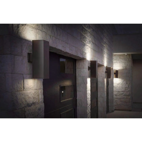 Aluminum Outdoor Up And Down Wall Lantern Light In Antique Bronze on stone wall, illuminating pathway with modern design