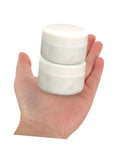 Hand holding two white containers of Two Piece Tile Repair Kit With Pro Grade Ceramic Paste Quick Dry Grout Filler.