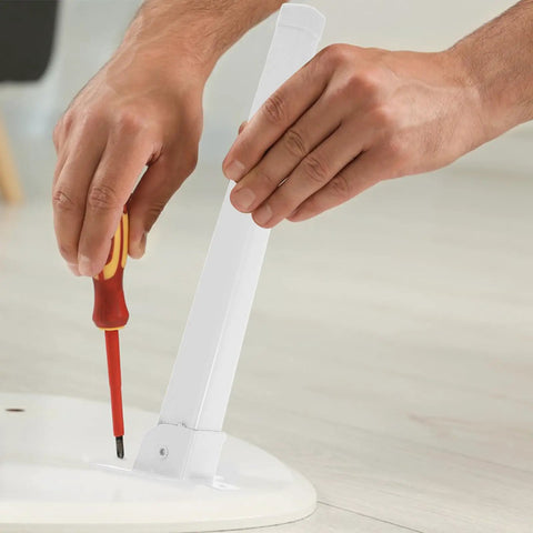 Installing Four Piece Replacement Table Legs For Window Sill And Coffee Tables with screwdriver on white surface.