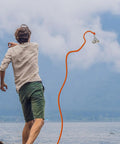 Man using 1000 Lb Neodymium Magnetic Fishing Kit With 66 Ft Rope, Dual Carabiners for treasure hunting by a lake
