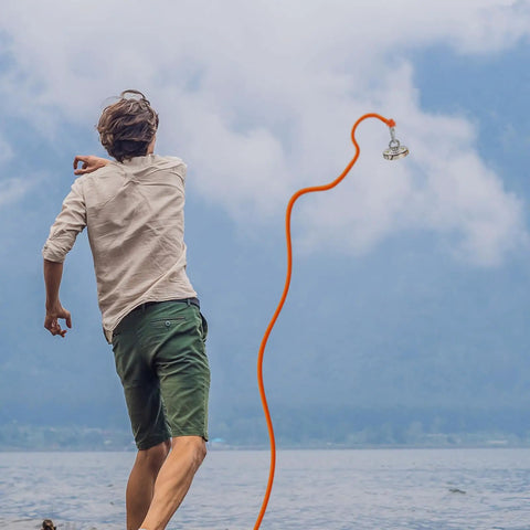 Man using 1000 Lb Neodymium Magnetic Fishing Kit With 66 Ft Rope, Dual Carabiners for treasure hunting by a lake