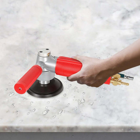 4-inch pneumatic wet stone polisher with red handles and silver body, air hose attached, on marble surface.
