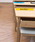 40 Pack Clear Adhesive Desk Nameplate Pockets, 13.5 by 4.7 Inch Self Adhesive Name Tag Sleeves on desks in classroom setting