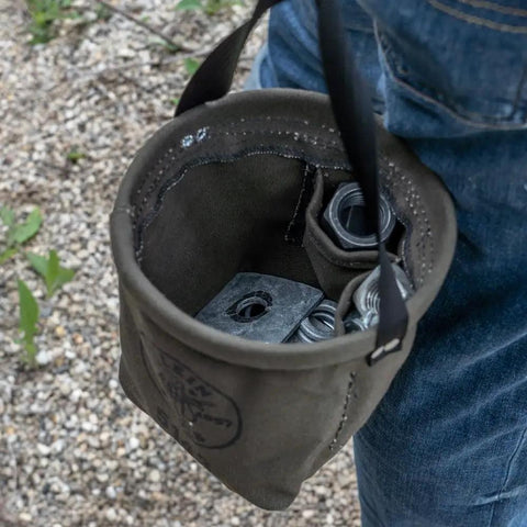 Canvas Tapered-Bottom Tool Bucket With Two Interior Pockets And Snap Clip Made From No 10 Canvas holding metal parts outdoors