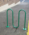 Green U-shaped bike rack installed on sidewalk with Zinc Plated Asphalt Anchor SP10-38 Five Eighths Inch By Six Inch 6 Pack