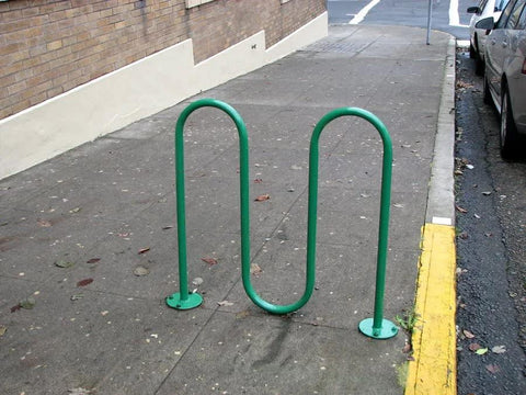 Green U-shaped bike rack installed on sidewalk with Zinc Plated Asphalt Anchor SP10-38 Five Eighths Inch By Six Inch 6 Pack