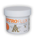 NitroFlux soldering paste jar, 57g 2oz size, labeled in English, French, Spanish with ASTM B813 standard icon on white background.