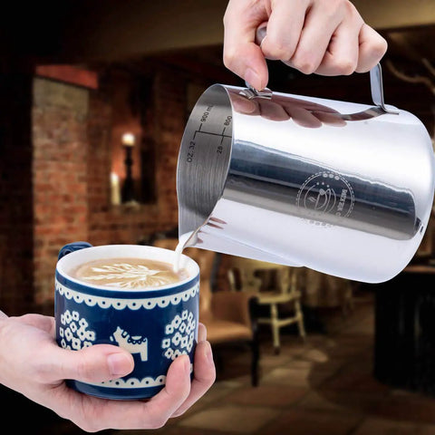32 Oz Milk Frothing Pitcher for Espresso and Latte Art Stainless Steel 304 Jug pouring milk into cappuccino in blue cup