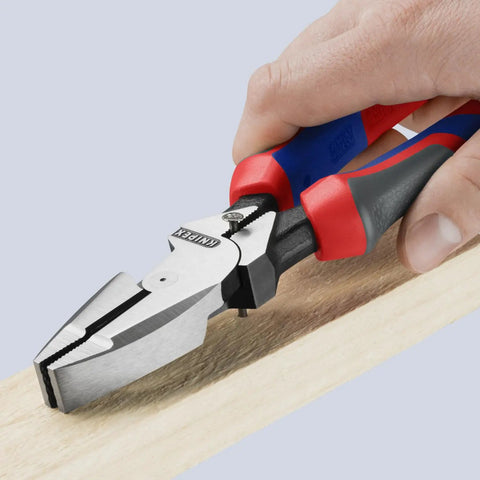 Hand using High Leverage Lineman's Pliers With New England Head And Multi Component Construction, 9-1/4 Inch Heavy Duty Electrician Tool on wood