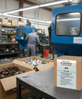 Industrial workshop with Fine Glass Bead Number Nine Sand Blasting Media box, machinery, and parts visible in the background.