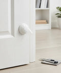 Peel And Stick Silicone Door Stopper No-Drill Self-Adhesive Wall Bumper on a white door in a home office setting