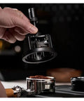 Slick Adjustable Coffee Distribution Tool And Rotatable Espresso Tamper Set For Badass Baristas 51 54 58 Millimeter Compatible held above coffee grounds.