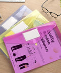 10 Pack Clear File Folders With Transparent Envelopes, Assorted Color Poly Document Folders With Label Pockets on a desk