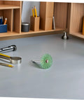 Mini Radial Bristle Disc Buffing Wheel With 3mm Shank For Detail Sanding And Polishing Tasks on a workspace.