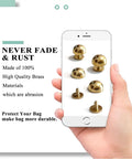Image of Top Shelf Solid Brass Bottom Guards For Handbags And Totes Round Screwback Feet 8 Pack with brass spikes shown on a phone.