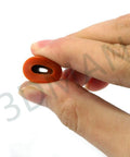 Close-up of a hand holding a silicone piece from the Heatbed Silicone Leveling Column Set for 3D Printers, 16 Pc Kit