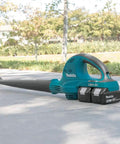 Badass 36V Cordless Leaf Blower Kit Cracks Yard Mess With Two 18V Batteries Pushing 155 CFM And 208 MPH Air Blast For Outdoor Cleanup Zero Hassle Brushless System Powers Long Sessions And Smooth Debris Clearing on a path with grass in background.
