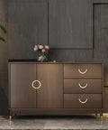 Stylish cabinet with golden copper hardware handles, wooden finish, three drawers, and decorative flowers on top.