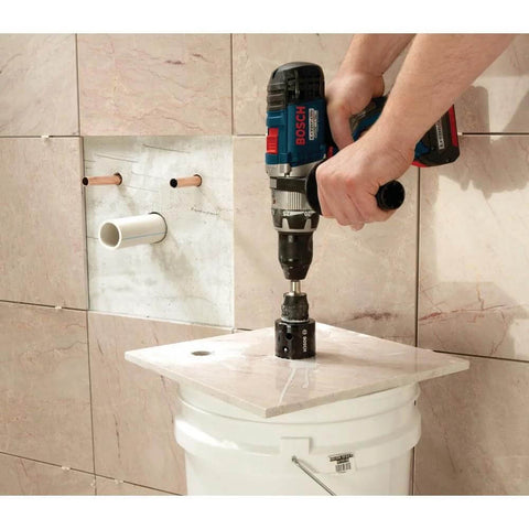 Bosch HDG12 1/2 in diamond hole saw on cordless drill, side view drilling into ceramic tile.