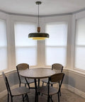 Mid Century Pendant Light 19 Inch Chandelier Featuring Bold Deep Green Shades Paired With Sleek Natural Wood And Polished Brass Accents above a round dining table.