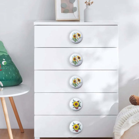 Kick Up Your Rustic Style With Eight Darn Cute Ceramic Kitchen Cabinet Drawer Knobs Featuring Pretty Sunflower And Butterfly Art For Dressers And Cupboards Designed For Smooth Grip Easy Install And Farmhouse Vibes on a white dresser.