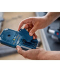 Hands opening battery compartment of Pro Grade Wall Scanner For Electricians And Contractors All In One Multi Function Stud Finder And Live Wire Detector Locates Wood Studs Metal Framing Copper Pipes And Live Electrical Wires Behind Drywall.