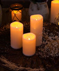 6 By 4 Inch Waterproof Outdoor Flameless Candles With Remote And Timer Battery Powered Flickering LED Pillar Candles, glowing on decorative tray with dried flowers, evening ambiance.