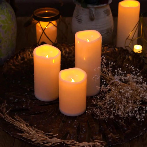 6 By 4 Inch Waterproof Outdoor Flameless Candles With Remote And Timer Battery Powered Flickering LED Pillar Candles, glowing on decorative tray with dried flowers, evening ambiance.