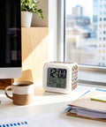 Top Notch Silent Digital Alarm Clock With Cool Starfish Shell Shape And Gentle Nightlight For Bedrooms Or Work Desks Checks Time Date Temperature Brings Easy Snooze Feature Down To Earth Vibe For Students And Crew on a desk with a coffee mug.