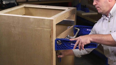 Person using Drawer Slide Jig With 3-Inch Face Clamps for Cabinets on wooden cabinet frame