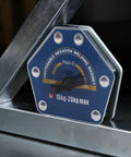 Solid One Button Degaussing Magnetic Welding Locator For Steel And Iron Pipe With 25 Kilos Suction Power Super Strong Multi Angle Positioning Fixture Tool For Heavy Duty Welding Projects displayed next to metallic surface.