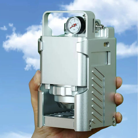 Portable Pneumatic Espresso Maker With 58mm Portafilter And Dual Pressure Gauges held against a blue sky.