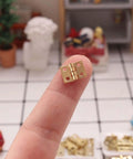 Miniature Door Hinges Set For Dollhouse 1/12 Scale With 4 Hinges And 16 Screws, DIY Micro Scene Decor, shown on fingertip