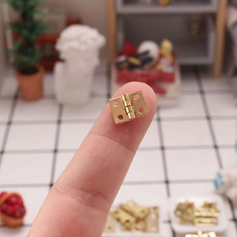 Miniature Door Hinges Set For Dollhouse 1/12 Scale With 4 Hinges And 16 Screws, DIY Micro Scene Decor, shown on fingertip