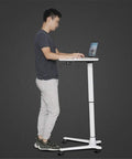 Man using Rock Solid Rolling Laptop Cart With Height Adjustable Standing Desk for relaxed work setup.