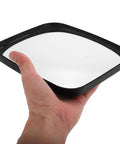 Hand holding a black-framed glass reflecting surface of a Wide Angle Safety Convex Mirror Rock Solid Wall Mount for Garage.