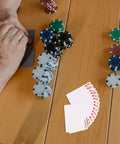 Person playing cards with poker chips, featuring 2 Sets Sublimation Blank Poker Cards 2.55 By 3.54 Inches for DIY crafts.