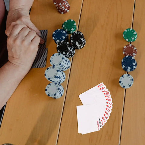 Person playing cards with poker chips, featuring 2 Sets Sublimation Blank Poker Cards 2.55 By 3.54 Inches for DIY crafts.