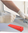 Heavy Duty Red Leveling Wedges 20 Pack Polymer Shims For Window And Furniture Installations in use, leveling a window frame.
