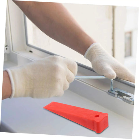 Heavy Duty Red Leveling Wedges 20 Pack Polymer Shims For Window And Furniture Installations in use, leveling a window frame.