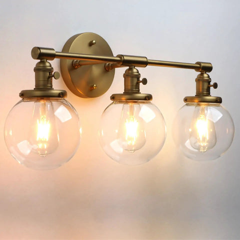 Three Light Antique Brass Wall Sconces With Clear Glass Globes Dope Industrial Vanity Lighting For Bathroom And Living Room