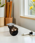 Heavy Duty 2 Inch Swivel Ball Caster with a sleek black wheel and metal flat mounting plate on a desk, ideal for furniture.