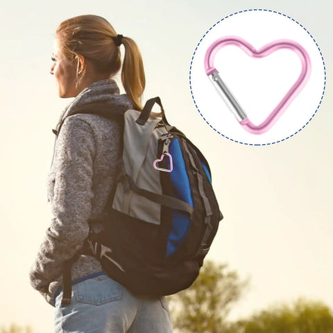 Woman with backpack using 10 Pack Heart Shaped Carabiners With Star Design, colorful clip detail displayed, outdoor scene.