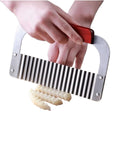 Handheld stainless steel crinkle cutter with red handle slicing wavy potato strips
