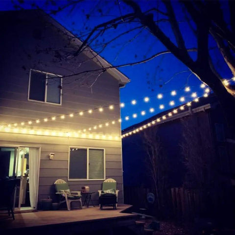 Outdoor String Light Hanging Kit With 100Ft Black Vinyl Coated 304 Stainless Steel Cable Globe String Lights Suspension Setup Includes Wire Rope Tension Turnbuckle And Eye Hooks For Easy Reliable Install lighting up a backyard patio space.