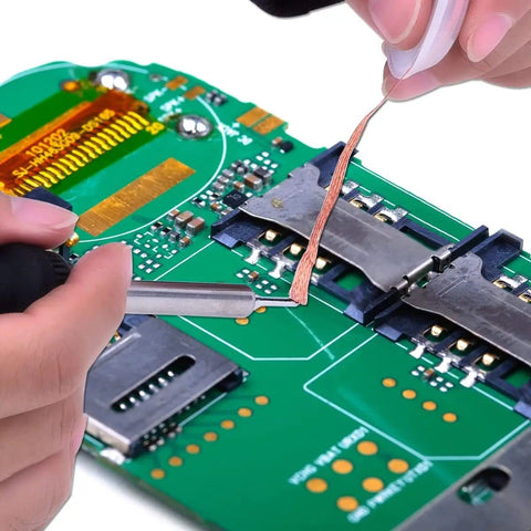 Hands using 5 Ft Pro-Grade Copper Desoldering Wick With No Clean Design And 280C Melting Point on a PCB for solder removal