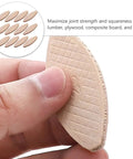 Hand holding a beech wood joining biscuit from a 100 Piece Pack Beech Wood Joining Biscuits Deliver Rock Solid Bonds When Gluing Wooden Boards Together While Making Carpentry Work Dead Simple With Every Biscuit Joiner.
