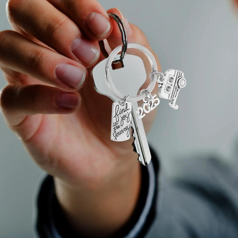 Must Have Travel Themed Keychain In Silver Zinc Alloy With Sturdy Build And Easy Clip Attach displayed in hand